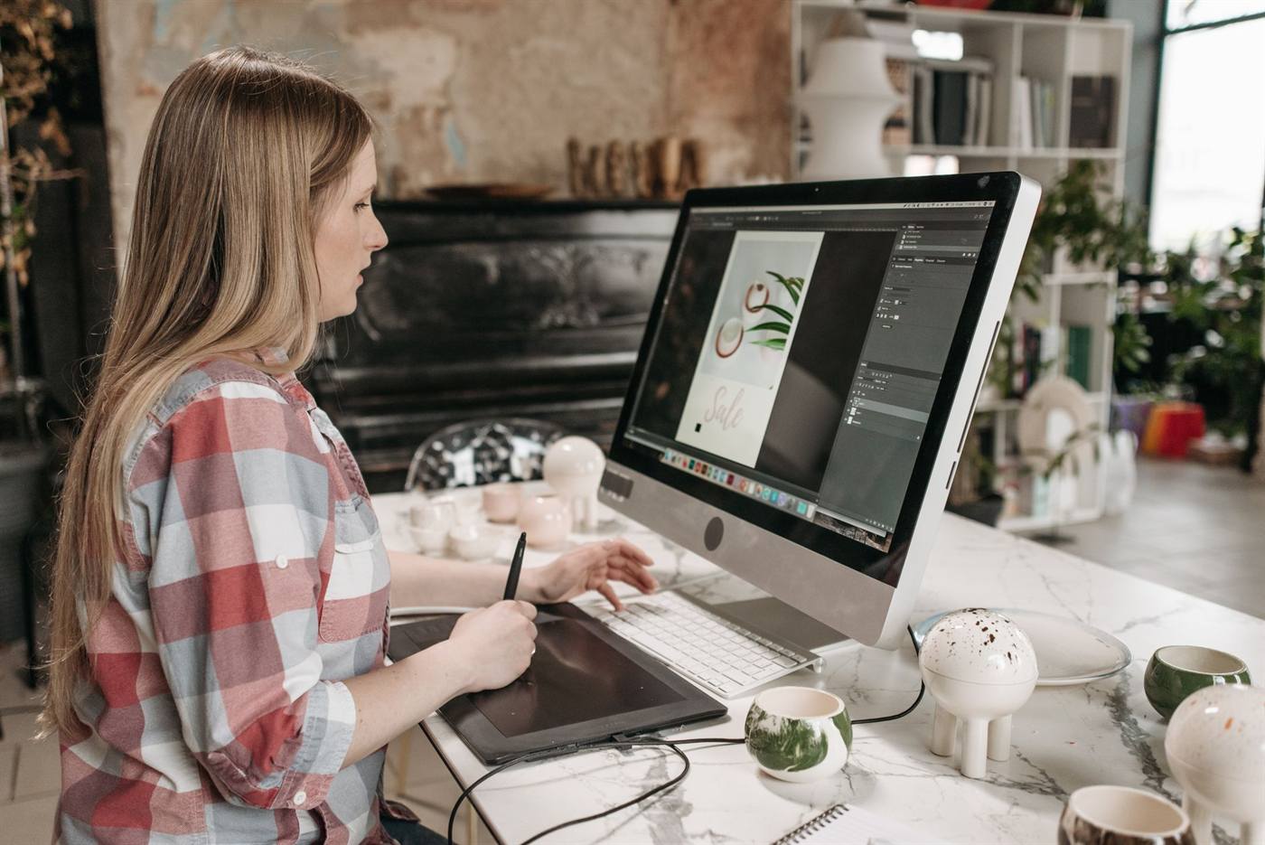 Designer working on a graphic with a drawing tablet at a studio desk